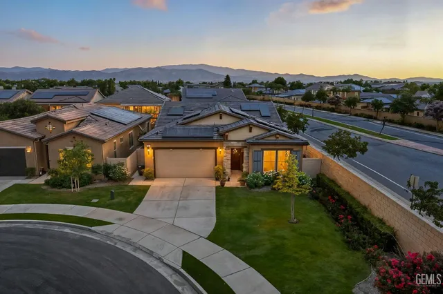 a view of a big house with a big yard and potted plants