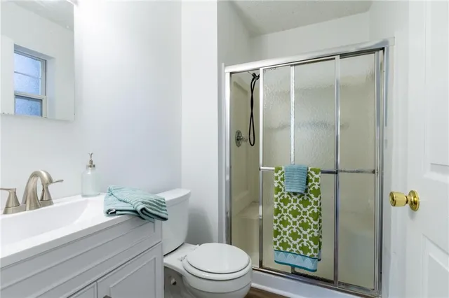 a bathroom with a granite countertop sink toilet and shower