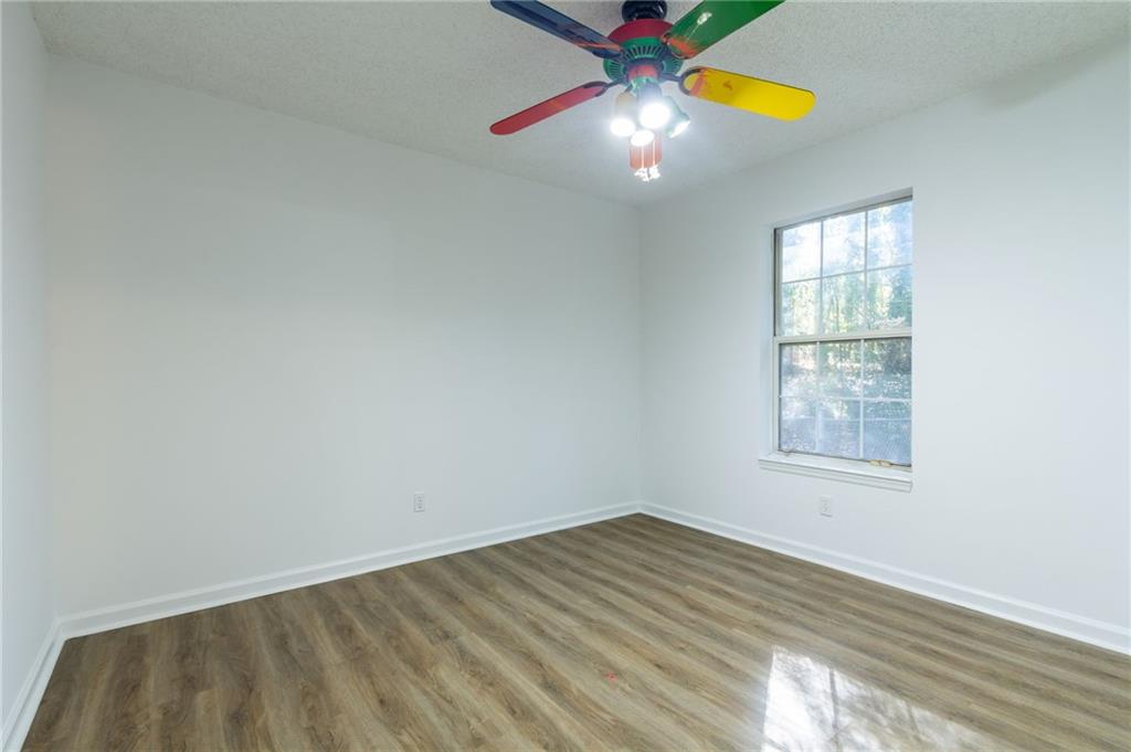 4908 Tarleton Drive Southwest Lilburn, GA 30047 - Photo 18 of 41 an empty room with windows and chandelier fan