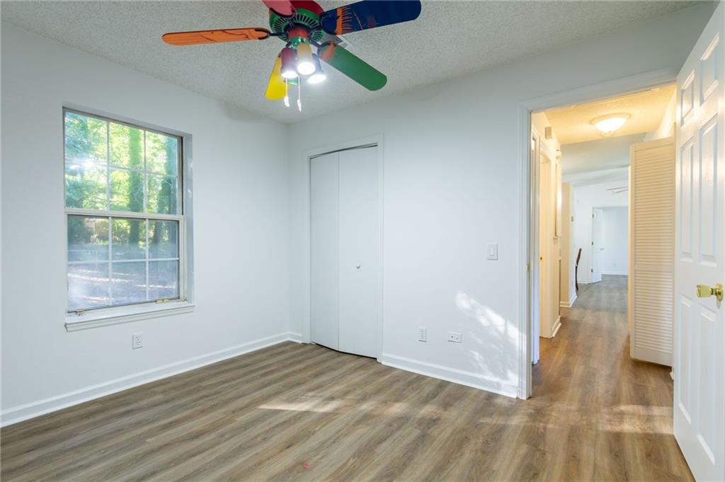 4908 Tarleton Drive Southwest Lilburn, GA 30047 - Photo 19 of 41 a view of empty room with wooden floor and fan
