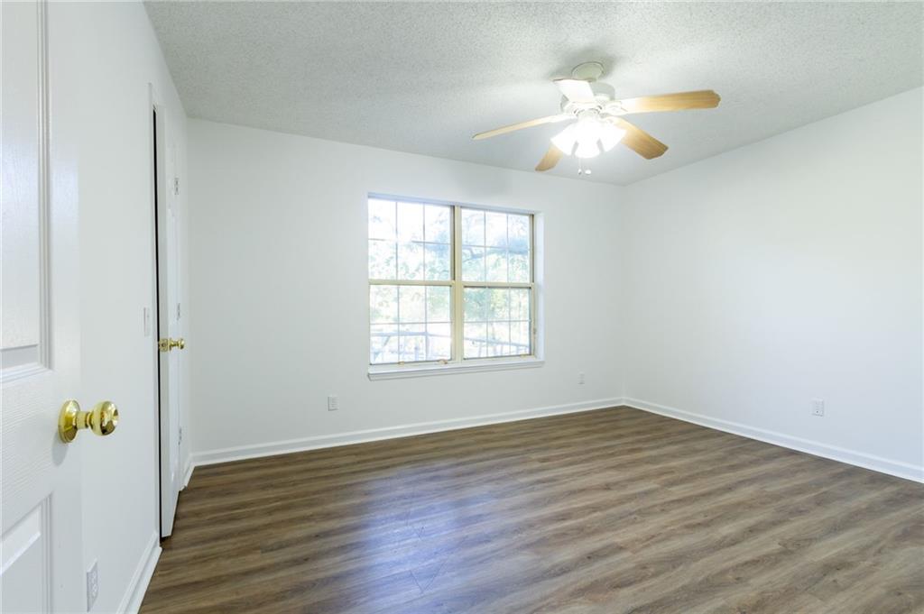 4908 Tarleton Drive Southwest Lilburn, GA 30047 - Photo 20 of 41 a view of an empty room with wooden floor and a window