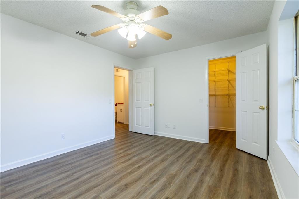 4908 Tarleton Drive Southwest Lilburn, GA 30047 - Photo 21 of 41 an empty room with wooden floor closet and windows