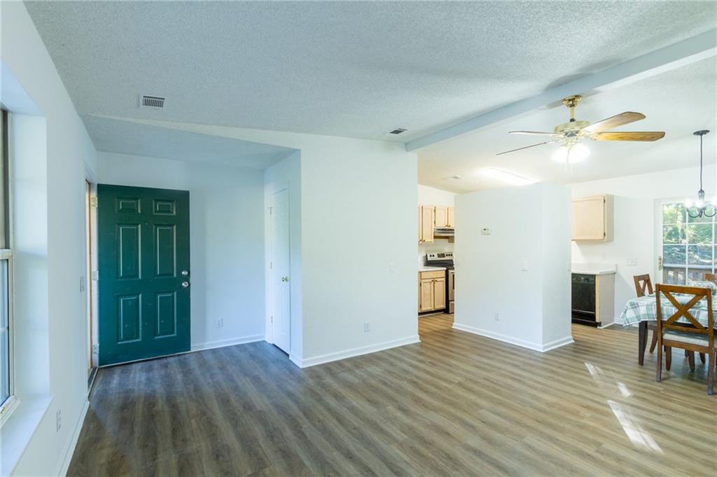 4908 Tarleton Drive Southwest Lilburn, GA 30047 - Photo 3 of 41 wooden floor in an empty room with a window
