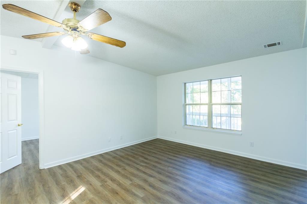 4908 Tarleton Drive Southwest Lilburn, GA 30047 - Photo 4 of 41 a view of an empty room with window and wooden floor