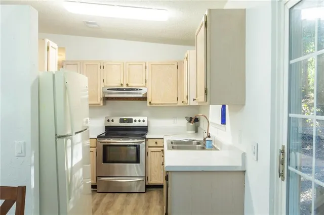 a kitchen with stainless steel appliances a stove a sink and a refrigerator