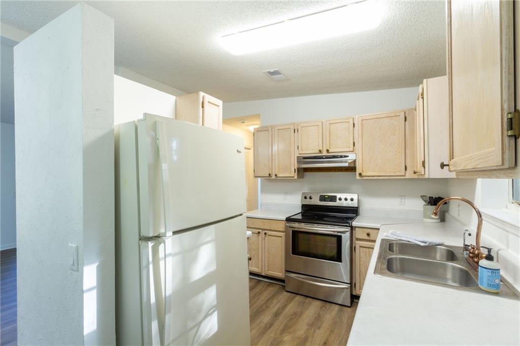 4908 Tarleton Drive Southwest Lilburn, GA 30047 - Photo 8 of 41 a kitchen with stainless steel appliances granite countertop a refrigerator stove and sink