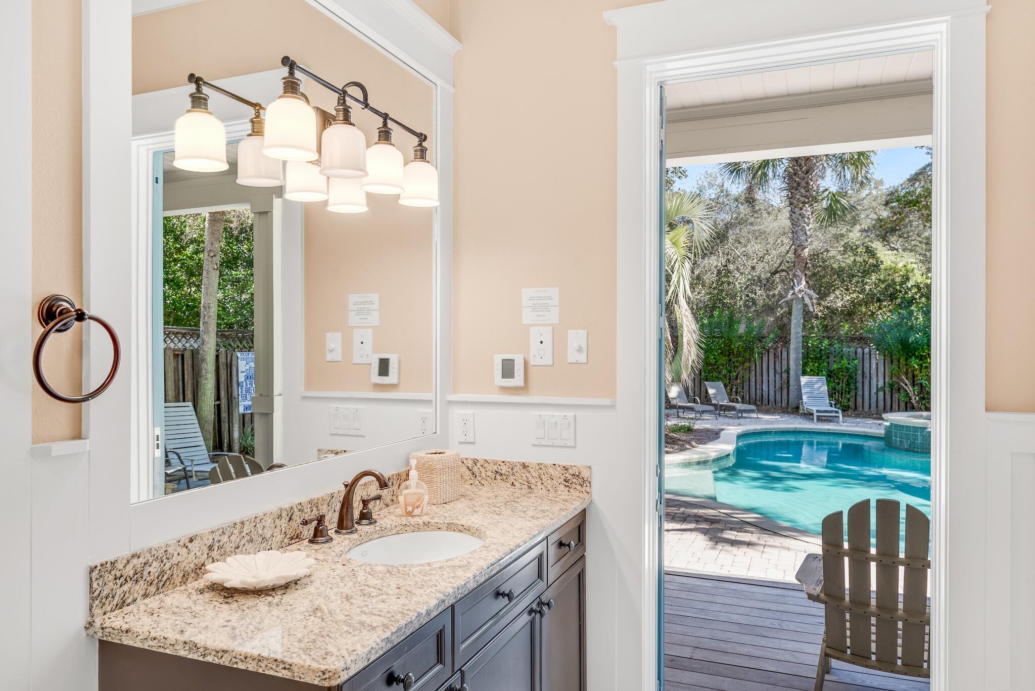 433 Defuniak Street Santa Rosa Beach, FL 32459 - Photo 47 of 57 a bathroom with a granite countertop sink and a mirror
