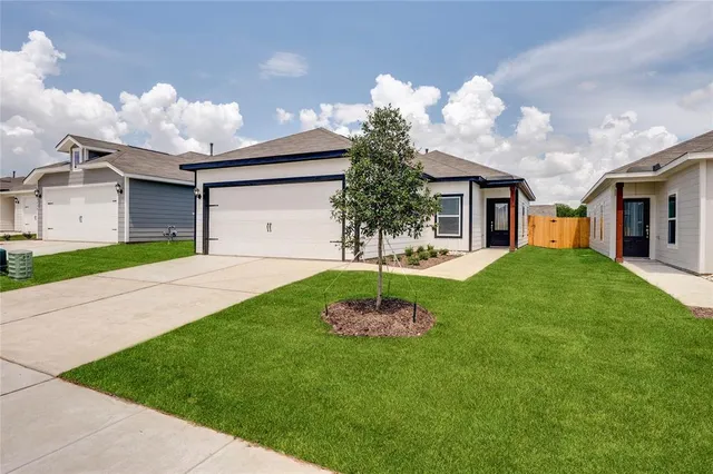 a front view of a house with a garden and yard