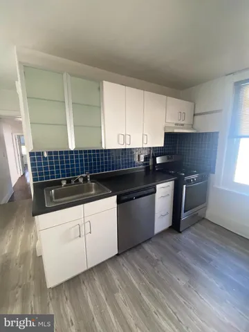 a kitchen with granite countertop a sink a counter space stainless steel appliances and cabinets