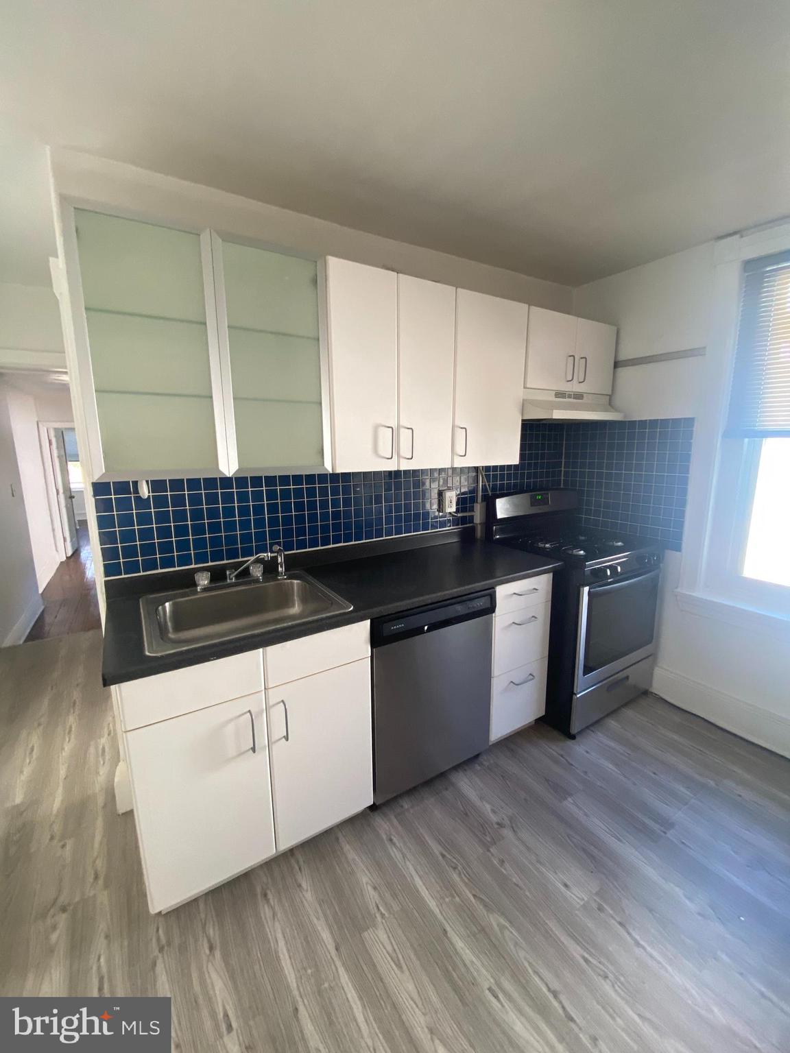 3700 Midvale Avenue, Unit 2 Philadelphia, PA 19129 - Photo 3 of 13 a kitchen with granite countertop a sink a counter space stainless steel appliances and cabinets