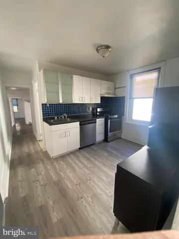 a kitchen with stainless steel appliances kitchen island granite countertop a stove a sink and a refrigerator