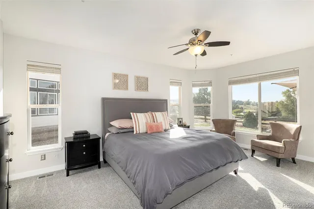 a large bedroom with a bed and a large window