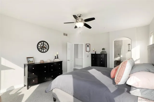 a spacious bedroom with a bed and ceiling fan