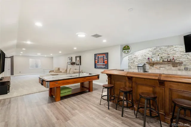 a dining hall with stainless steel appliances kitchen island a table and chairs in it