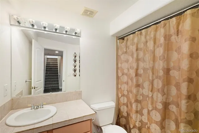 a bathroom with a sink vanity mirror and toilet
