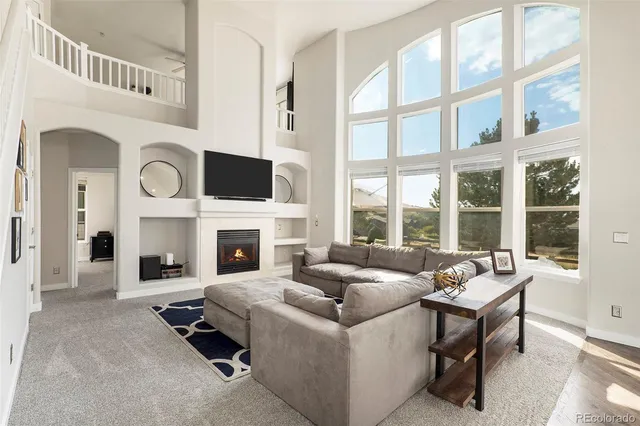 a living room with furniture a fireplace and a large window