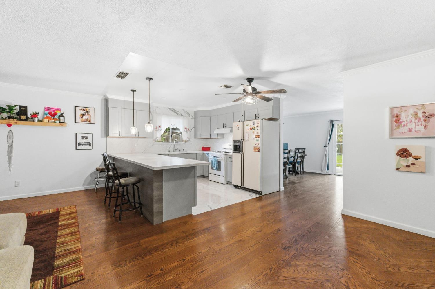 204 West Cesar Chavez Boulevard Fresno, CA 93706 - Photo 12 of 28 a view of a kitchen with dining room and wooden floor