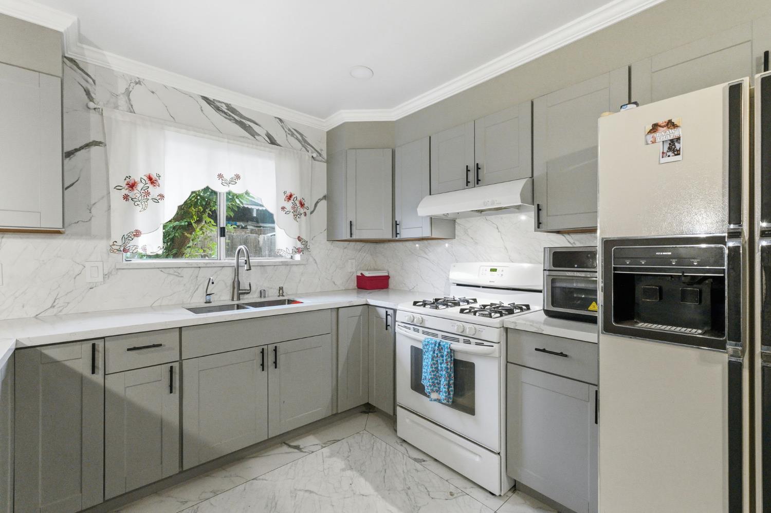 204 West Cesar Chavez Boulevard Fresno, CA 93706 - Photo 14 of 28 a kitchen with cabinets appliances and a sink