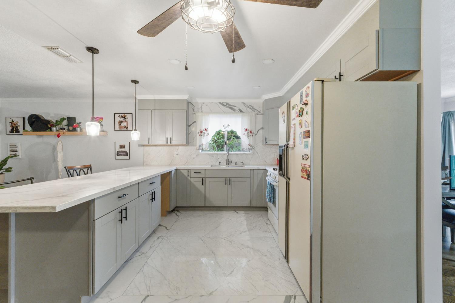 204 West Cesar Chavez Boulevard Fresno, CA 93706 - Photo 15 of 28 a kitchen with a sink a counter top space stainless steel appliances and cabinets
