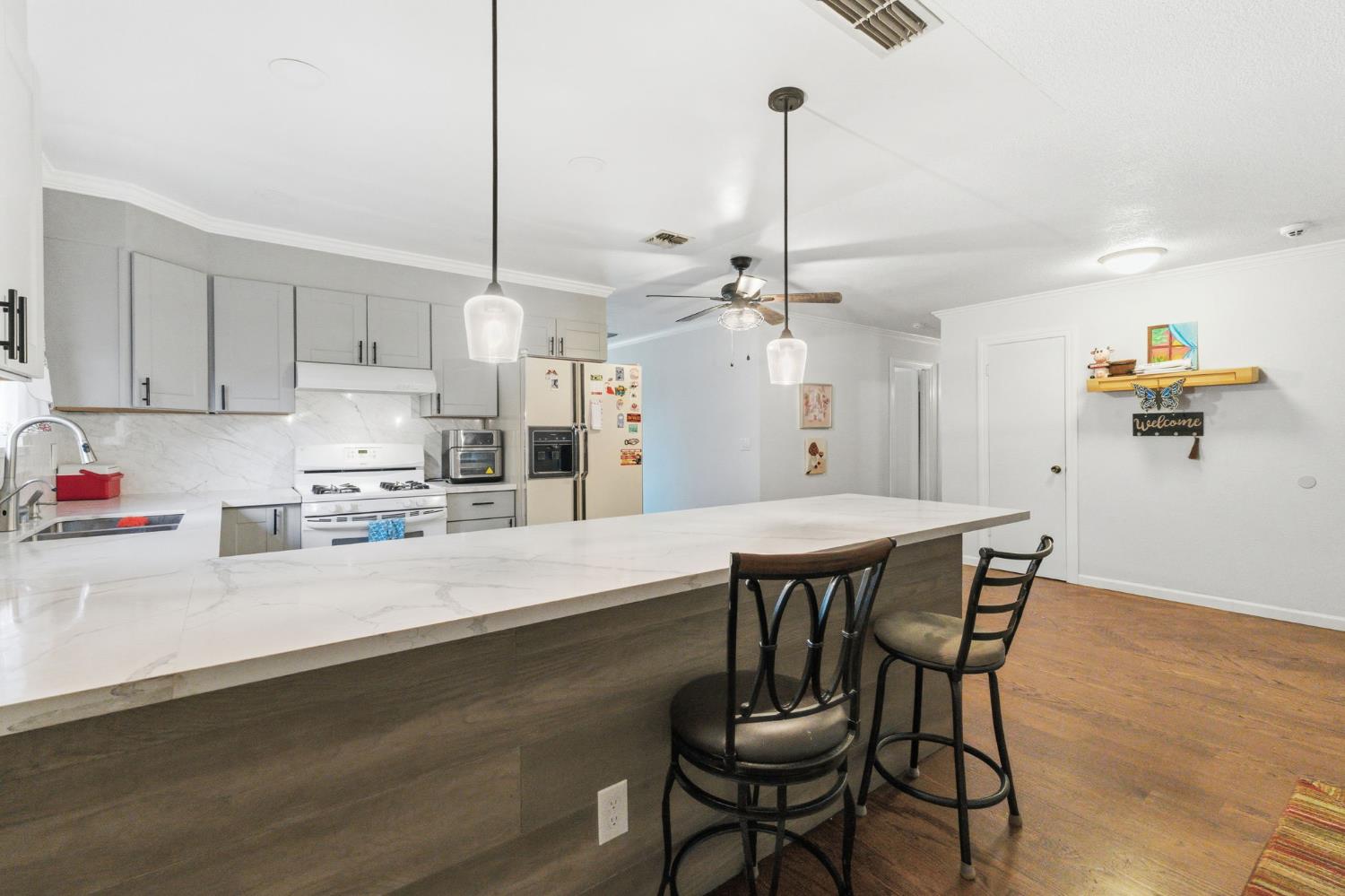 204 West Cesar Chavez Boulevard Fresno, CA 93706 - Photo 16 of 28 a kitchen with stainless steel appliances kitchen island granite countertop a table chairs sink and cabinets