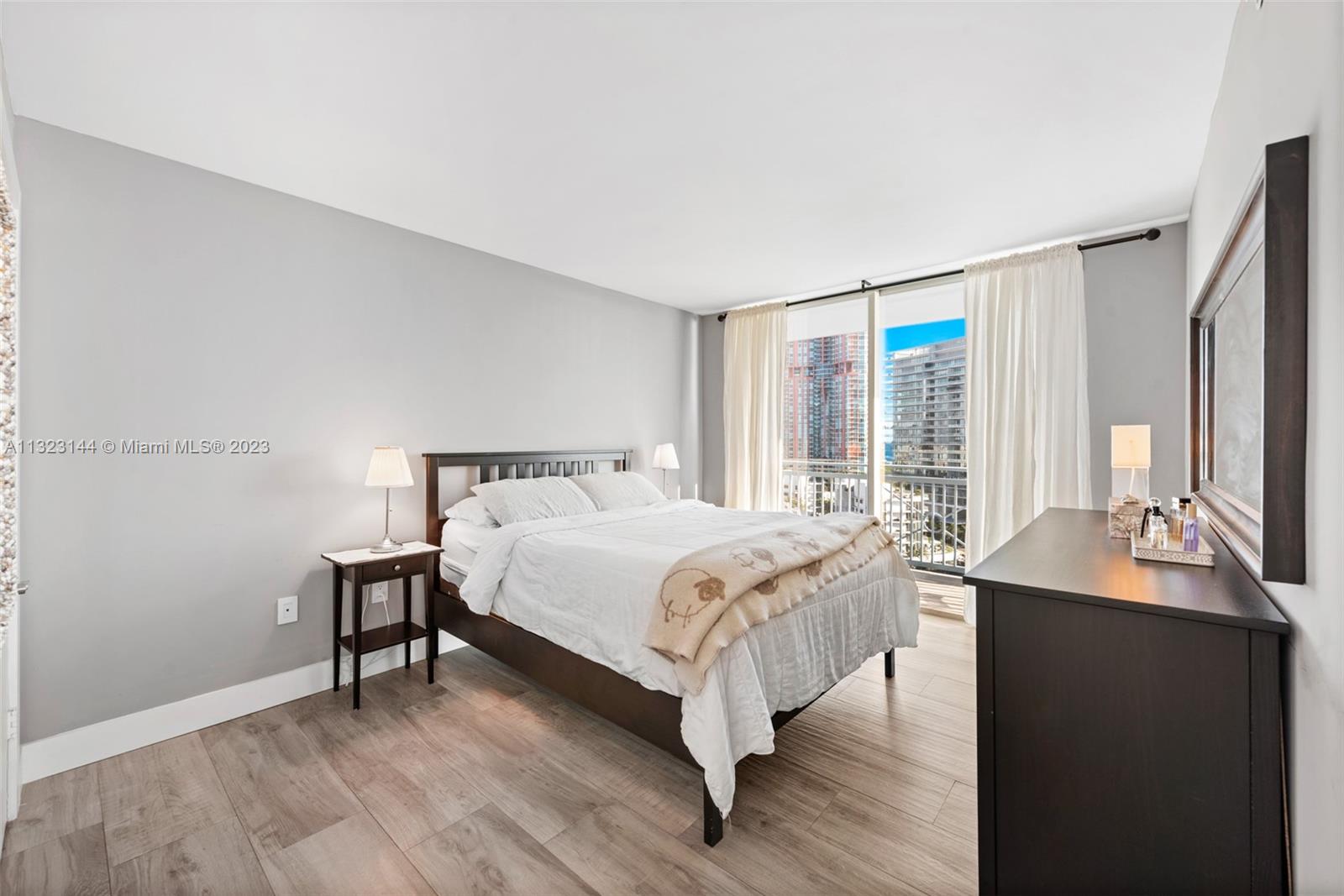 90 Alton Road, Unit 1602 Miami Beach, FL 33139 - Photo 16 of 34 a bedroom with a bed lamp closet and window