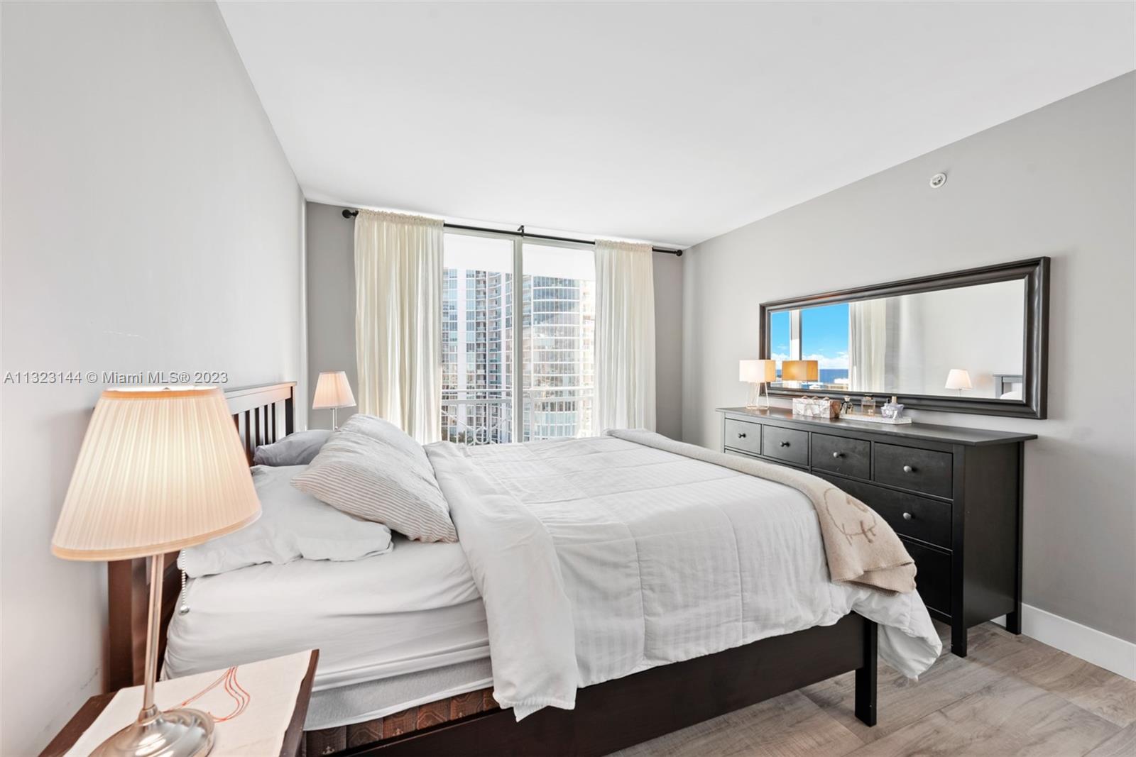 90 Alton Road, Unit 1602 Miami Beach, FL 33139 - Photo 18 of 34 a bedroom with a bed and a lamp
