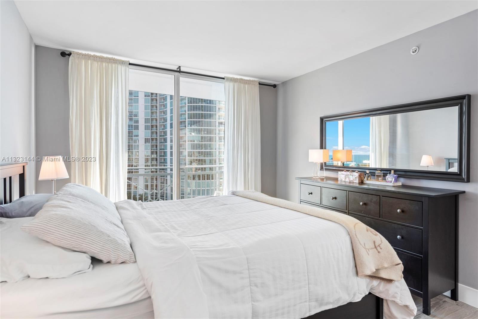 90 Alton Road, Unit 1602 Miami Beach, FL 33139 - Photo 19 of 34 a bedroom with a large bed and a large window