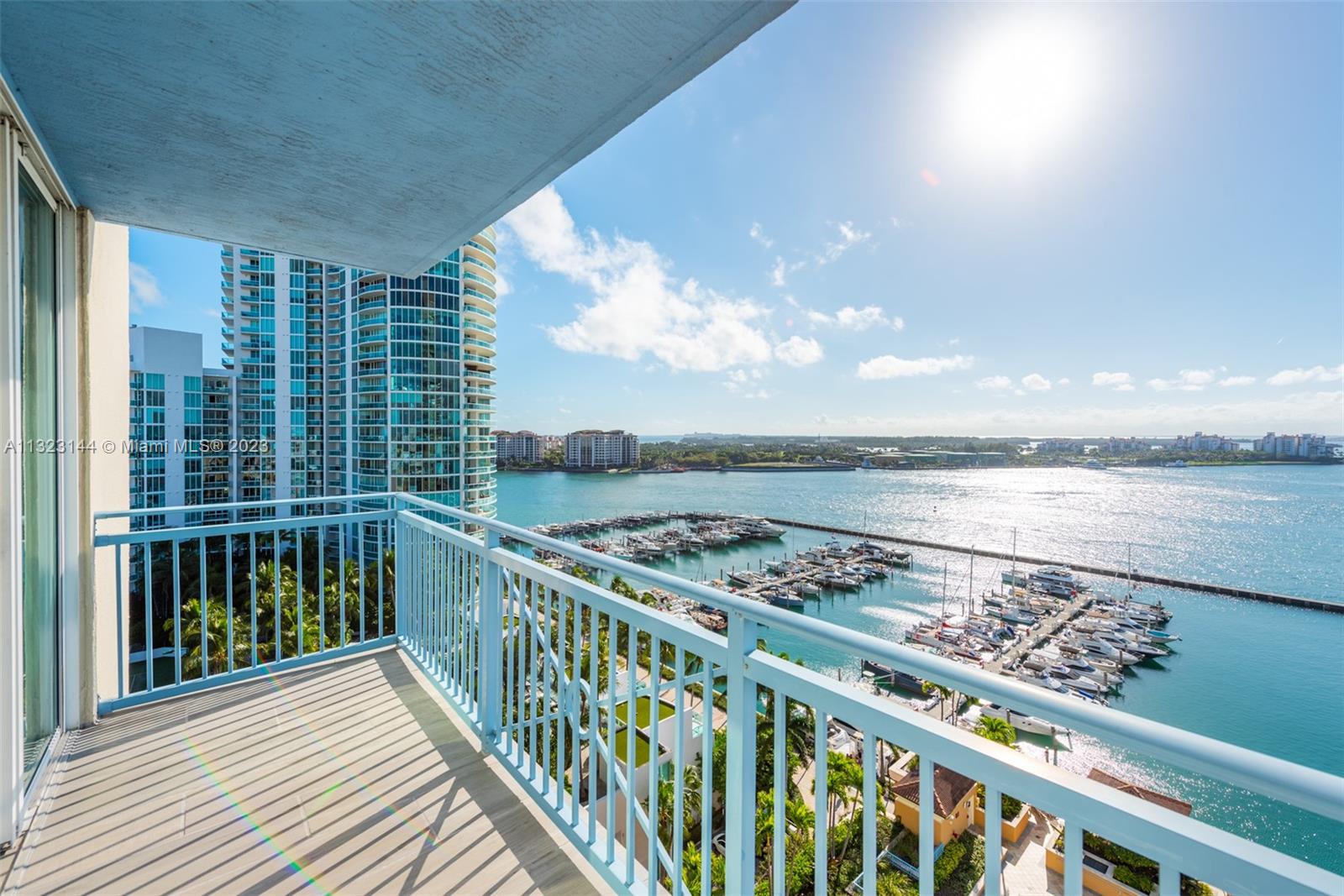 90 Alton Road, Unit 1602 Miami Beach, FL 33139 - Photo 5 of 34 a view of a balcony with wooden chairs and city view