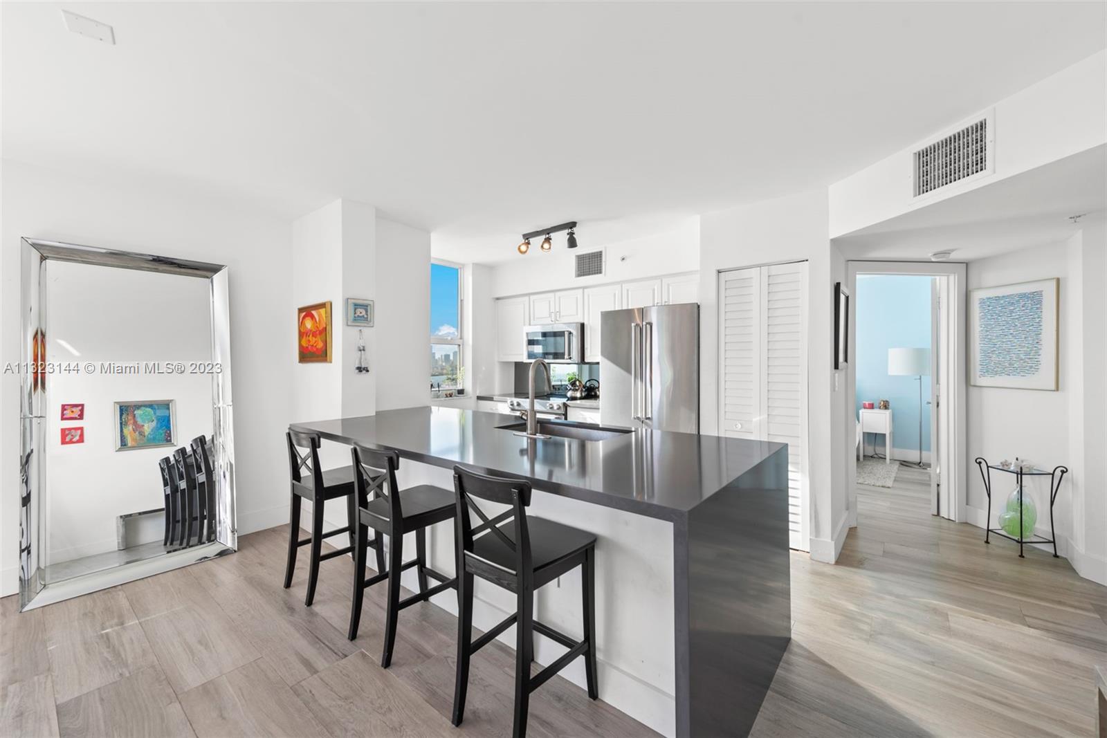 90 Alton Road, Unit 1602 Miami Beach, FL 33139 - Photo 9 of 34 a view of a dining room with furniture and wooden floor