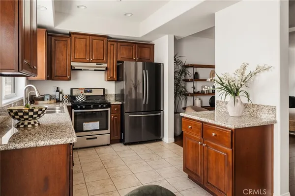 a kitchen with stainless steel appliances granite countertop a refrigerator and a sink