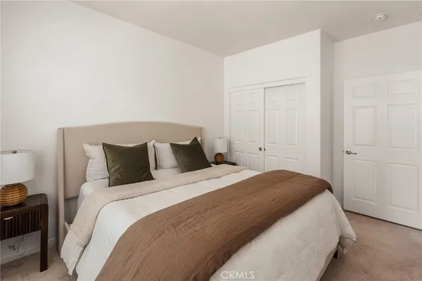 a bedroom with a bed and a potted plant