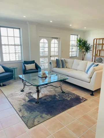 a large white kitchen with stainless steel appliances kitchen island granite countertop a table and chairs in it