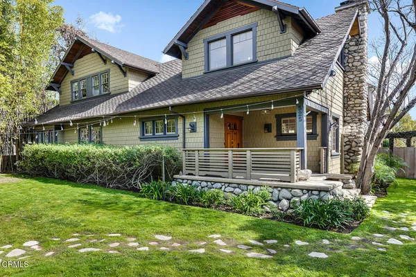 a view of a house with brick walls and a yard with plants
