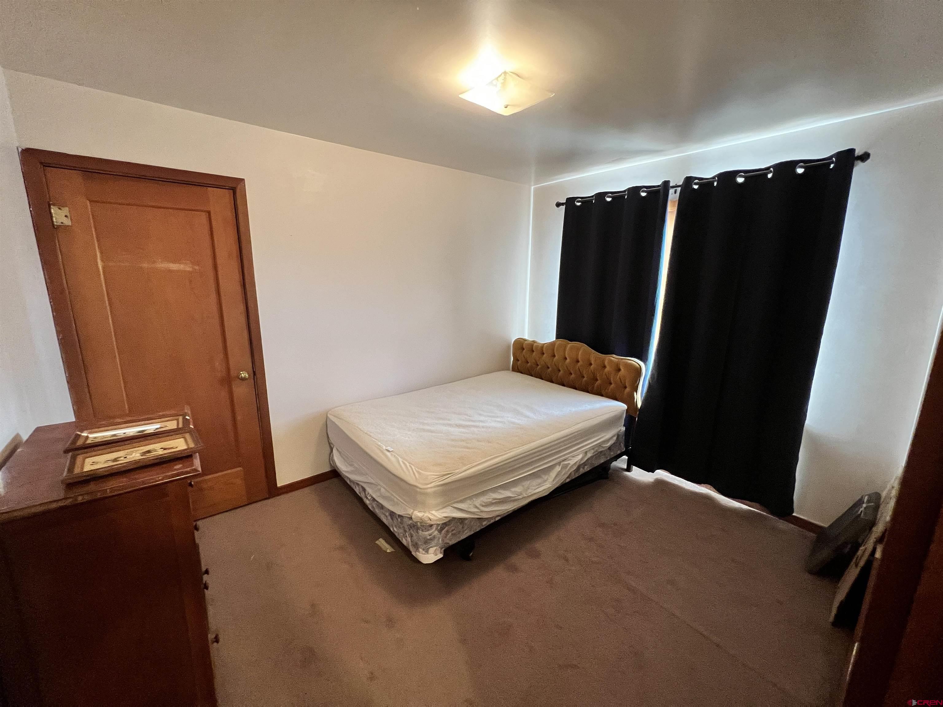 8139 5600th Road Olathe, CO 81425 - Photo 20 of 30 a bedroom with a bed and a mirror