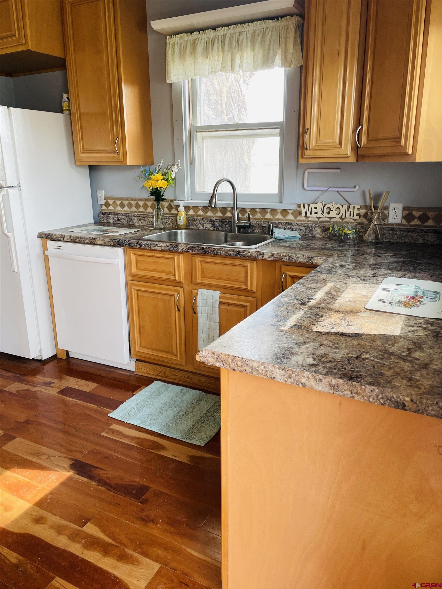 8139 5600th Road Olathe, CO 81425 - Photo 26 of 30 a kitchen with granite countertop a sink a stove and cabinets