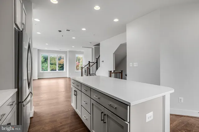 a kitchen with kitchen island a sink appliances and a counter top