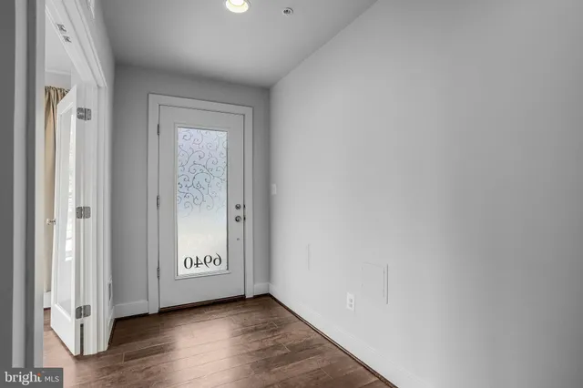 a view of an empty room with wooden floor and closet