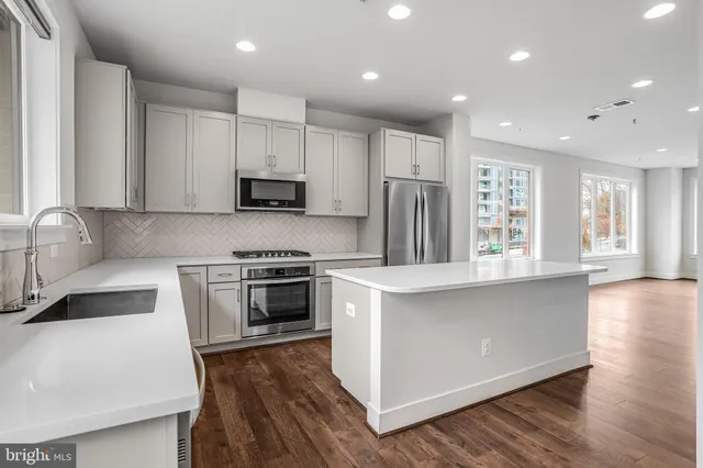 a kitchen with stainless steel appliances granite countertop a stove a sink and a refrigerator