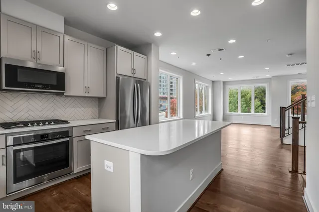 a kitchen with stainless steel appliances a stove a sink and a refrigerator