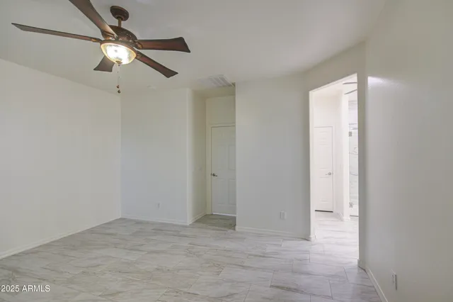 a view of empty room with ceiling fan