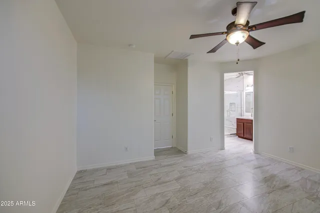 a view of an empty room with a ceiling fan