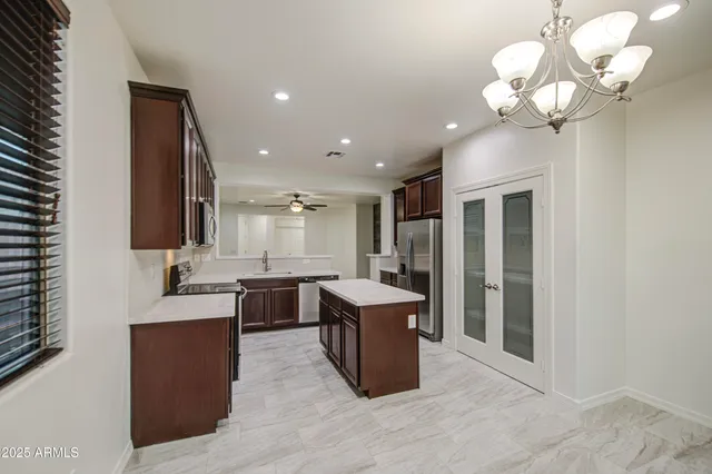 a kitchen with a chandelier and wooden cabinets