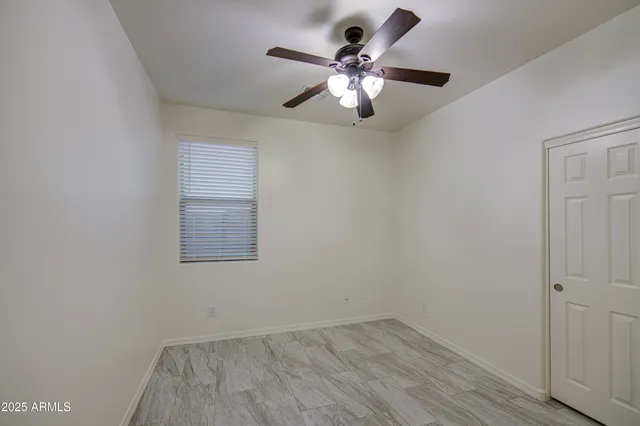 a view of a room with a ceiling fan and hardwood floor