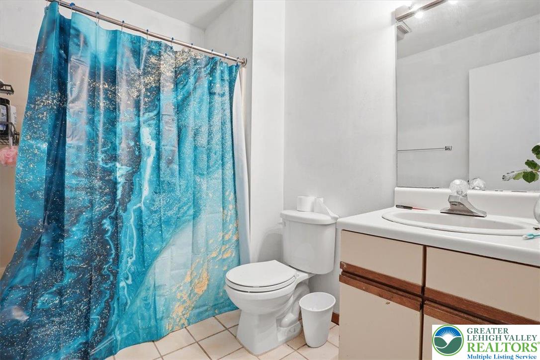 3301 Windermere Drive Bushkill, PA 18324 - Photo 22 of 71 a bathroom with a toilet a sink and a mirror