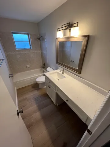 a bathroom with a double vanity sink toilet mirror and bathtub