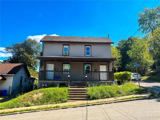 a front view of a house with a garden