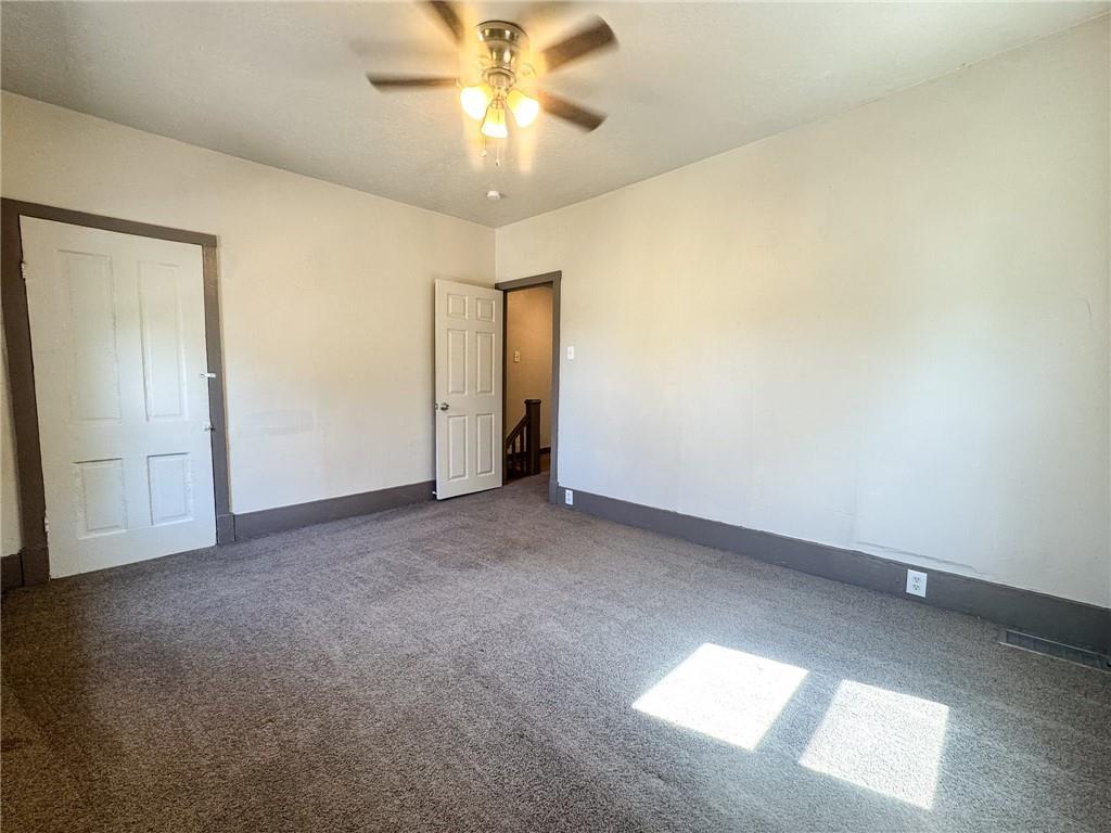 121 Heim Avenue Butler, PA 16001 - Photo 10 of 16 an empty room with a chandelier fan and windows