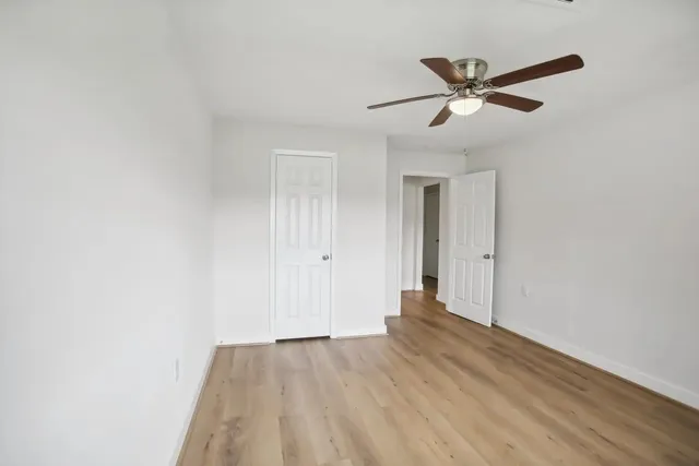 a view of a room with wooden floor and white walls