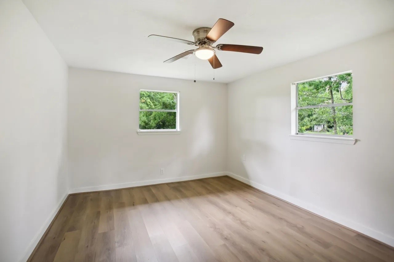 906 S Road Baytown, TX 77521 - Photo 18 of 32 an empty room with wooden floor and windows