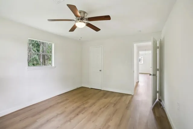 a view of a big room with wooden floor closet and windows